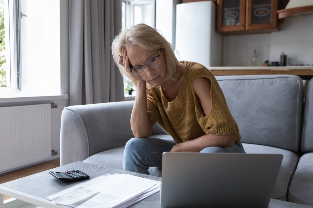 Concerned middle-aged woman looking at finances on laptop