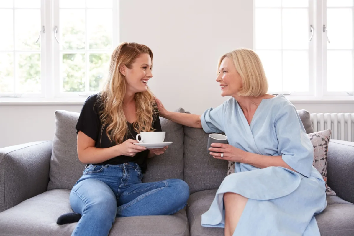 Mother sitting on the sofa with her adult daughter