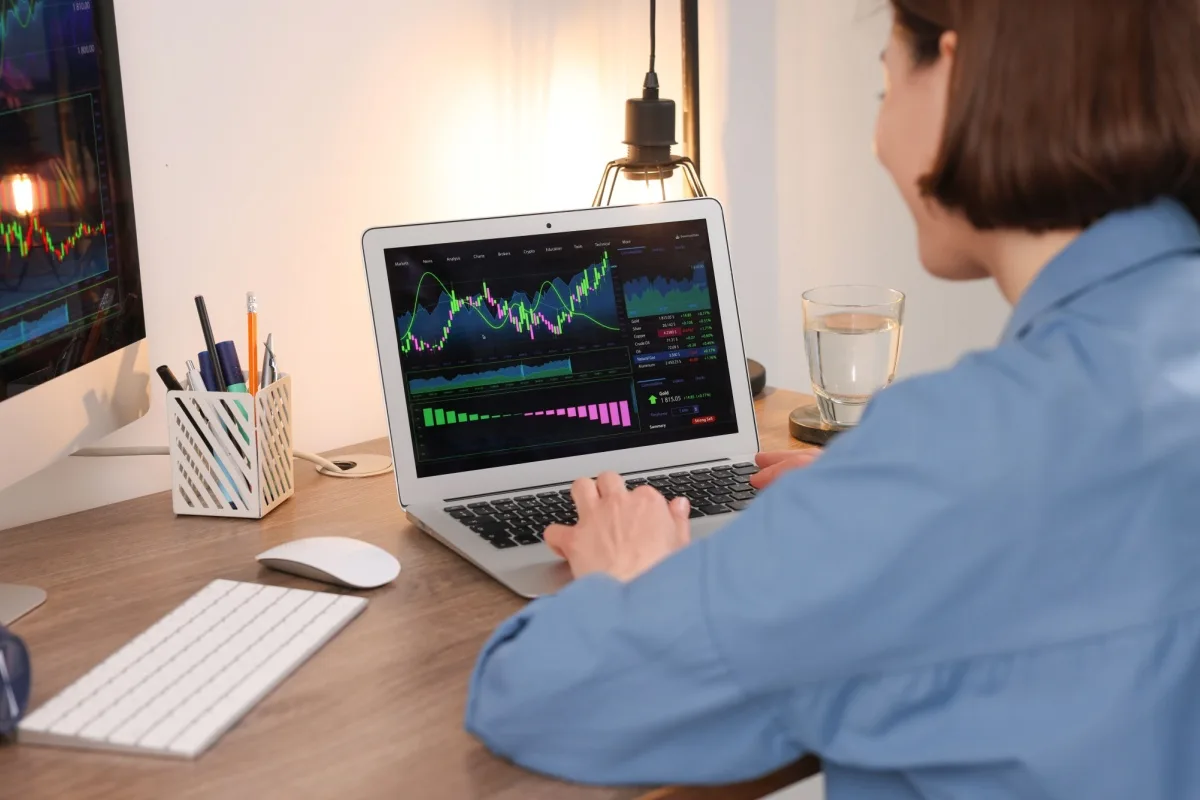 Woman looking at stock market data on a laptop