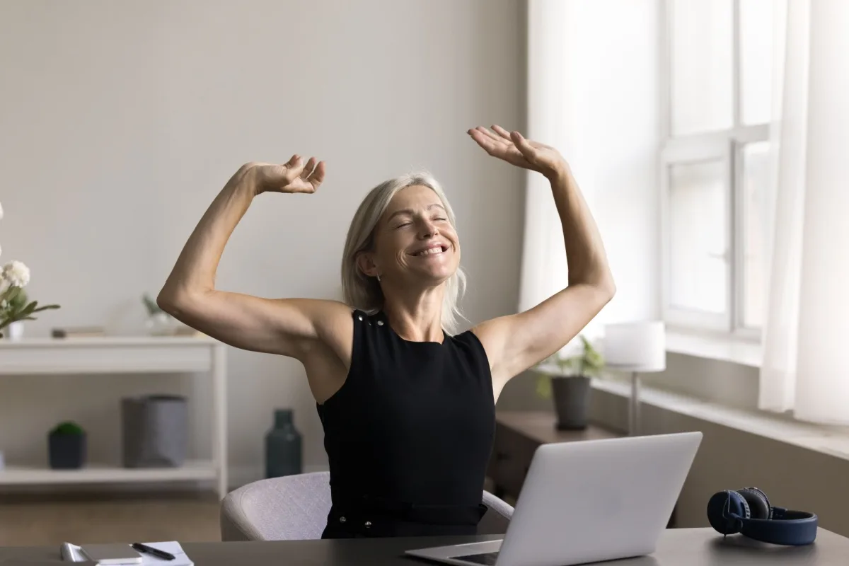Happy middle-aged woman sitting at a laptop
