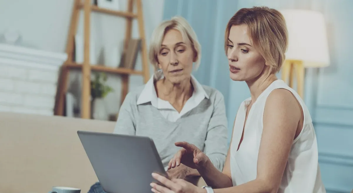 Female financial adviser and senior female client looking at a laptop