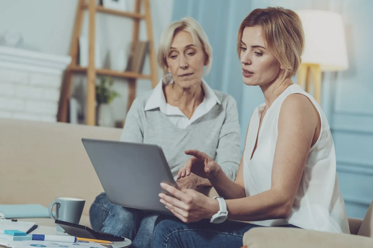 Female financial adviser and senior female client looking at a laptop