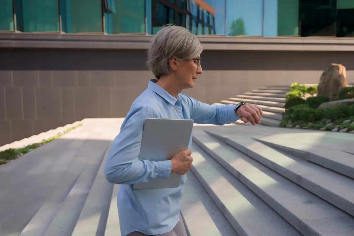 Middle-aged woman looking anxiously at her watch