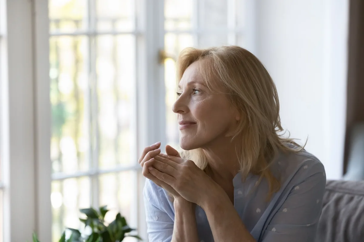 A happy woman looking out the window.
